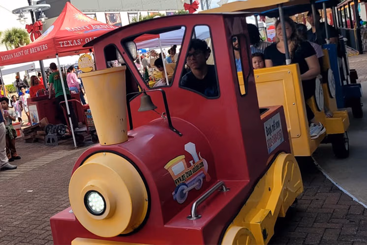 Colorful trackless train ride for children and families at an outdoor event