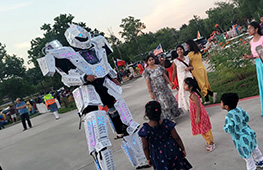 Guests interacting with an LED robot performer during a celebration