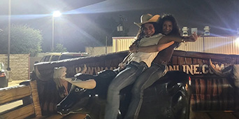 Professional mechanical bull setup with safety mat and operator
