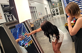 Guests using an interactive photo booth with touchscreen and fun photo props